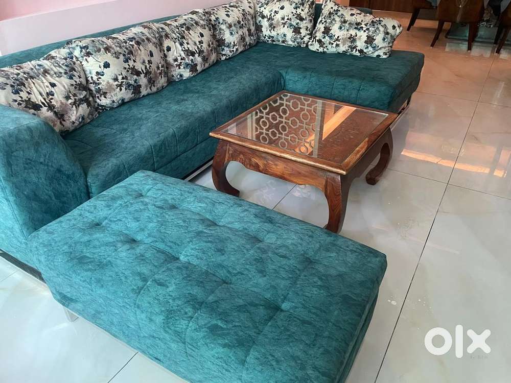 This is an L shaped sofa with an ottoman .