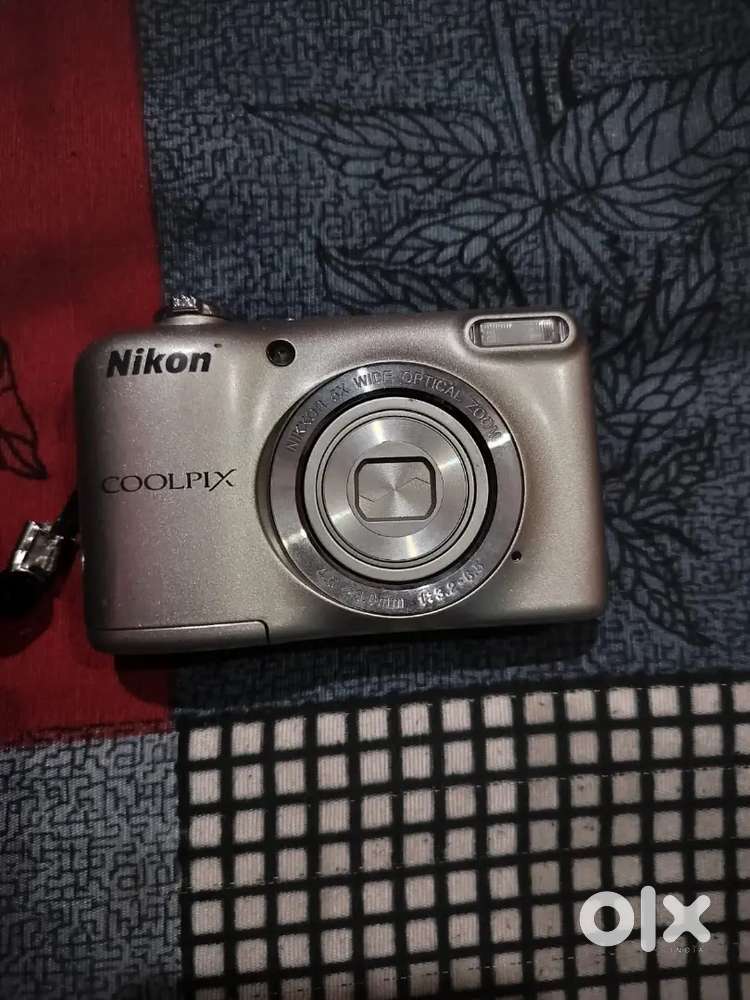 The camera features a 5x optical zoom NIKKOR lens.