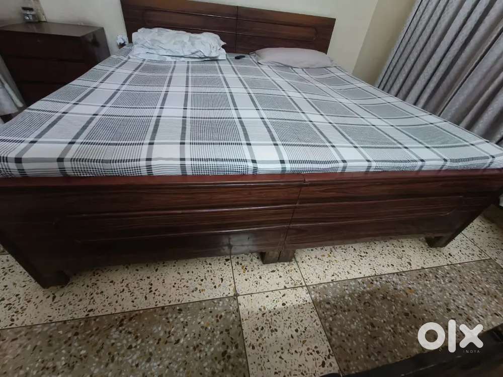 King size bed with side table and mattress.