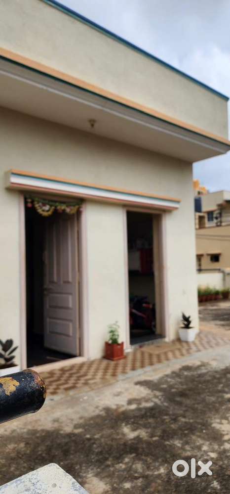 Single room with attached bathroom, cot with bed, storage shelves,