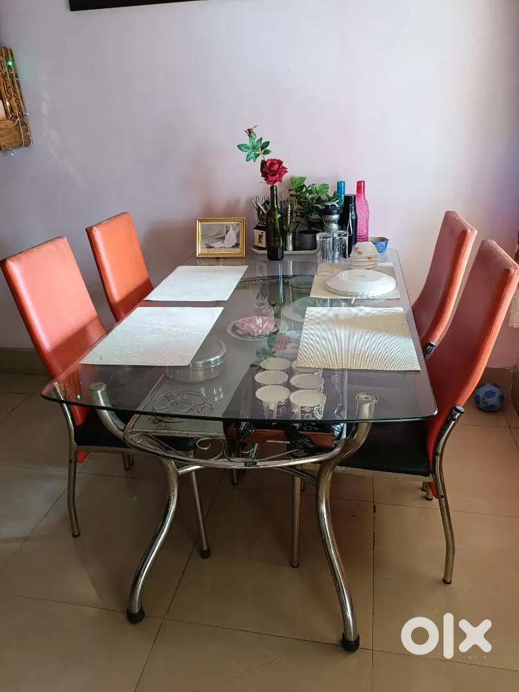 A glass top- double selves 6 sitter dining table , with 4 chairs.