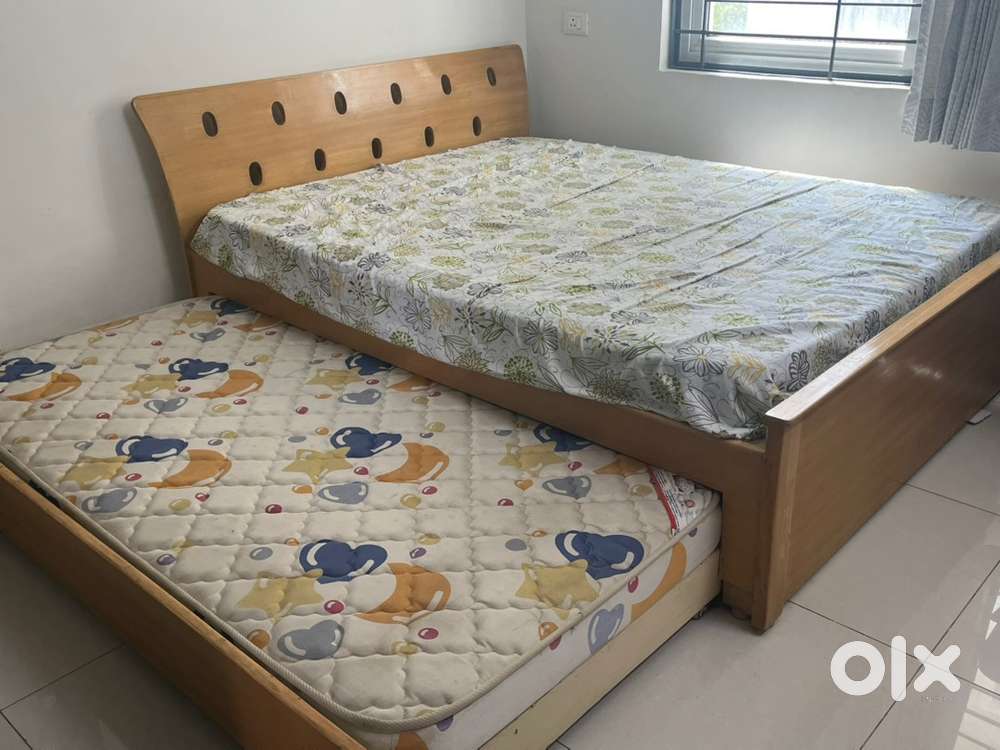 Rubberwood queen sized cot with an additional pull out cot