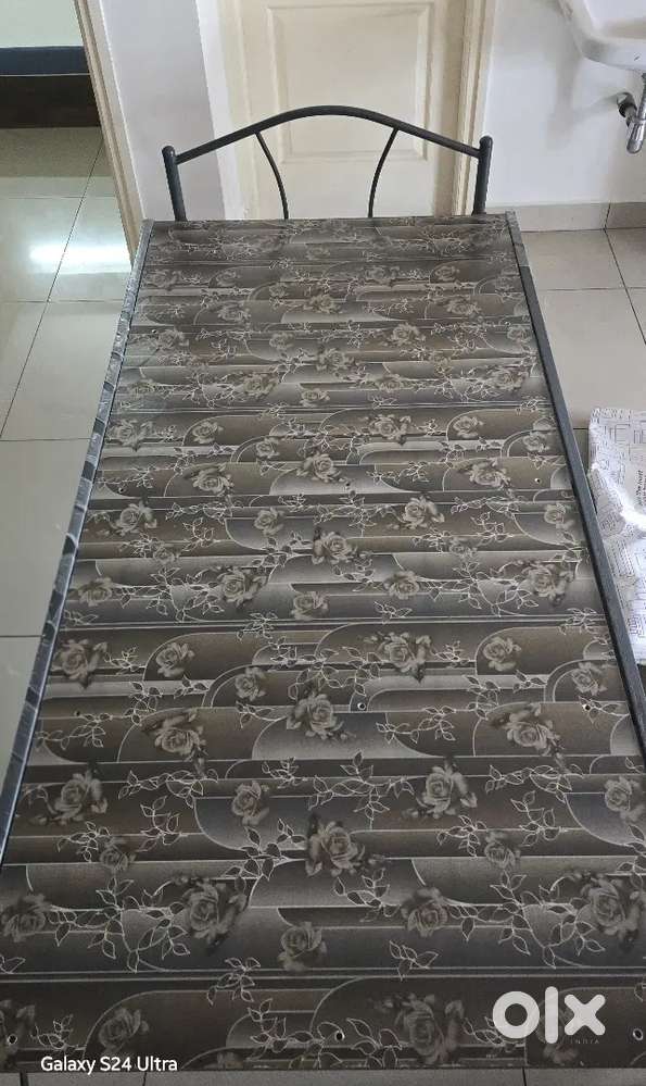 Metal single bed with mattress.