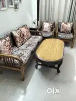 A five seater wooden sofa with table is ready for sale.