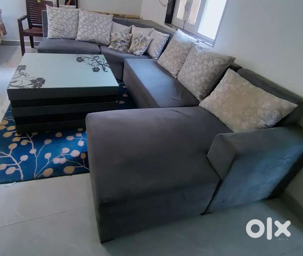 7 seater sofa with a center table and 2 pouffees