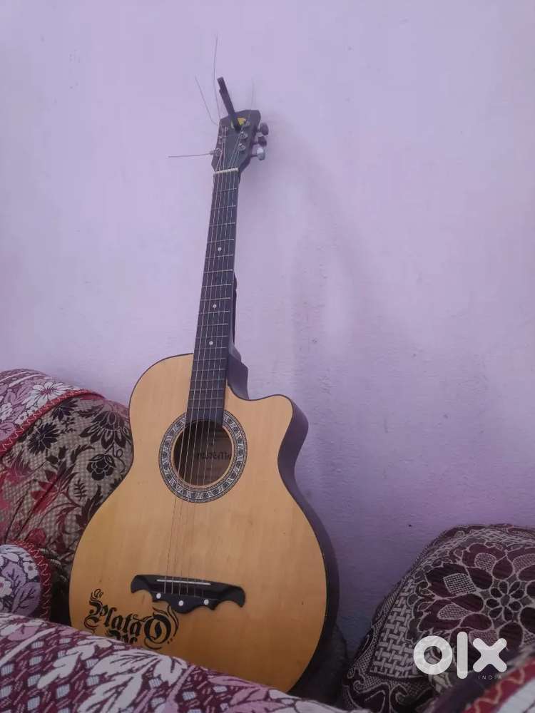 Acoustic guitar Natural wood colour with a capo and strings