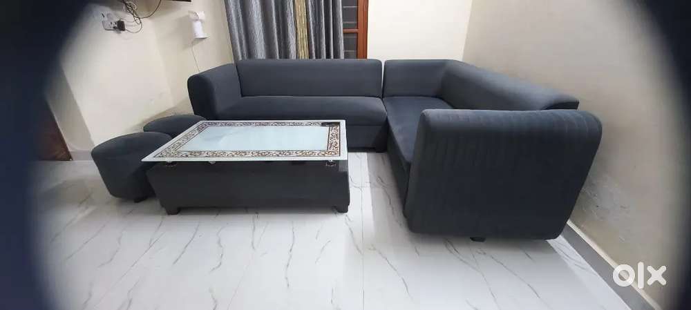 L-shaped sofa with two stools and a table