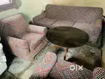 5 seater sofa and a centre table with thick glass top and teak wood ca