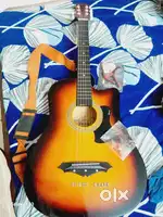 NEW GUITAR WITH BELT, CAPO AND GUNS