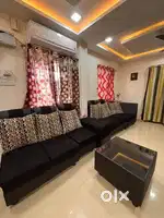 Well maintained black and spacious sofa with glass tea table