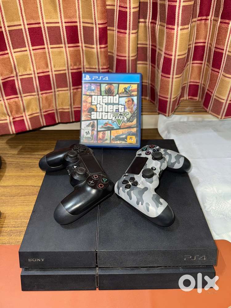 PlayStation 4 with 2 controllers and 5 disc games.